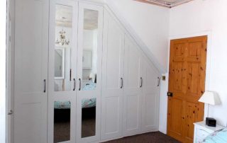 beautiful white and mirrored door, custom fitted wardrobe in a loft conversion