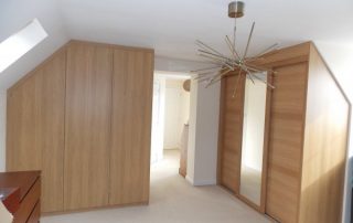 beautiful high-end timber fitted wardrobes with sliding doors in a prestigious loft conversion