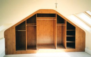 inside a knotty pine finished wardrobe with hinged doors custom fitted