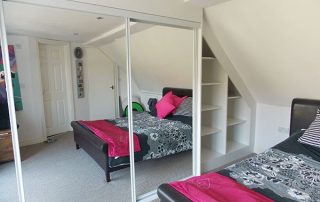 white and mirrored sliding wardrobe door in loft conversion